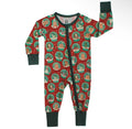 A baby long-sleeve footless one-piece sleeper with a festive Christmas print, featuring a red background with green circular snow globes containing holiday illustrations, a dark green collar, cuffs, and leg cuffs, and a front zipper.