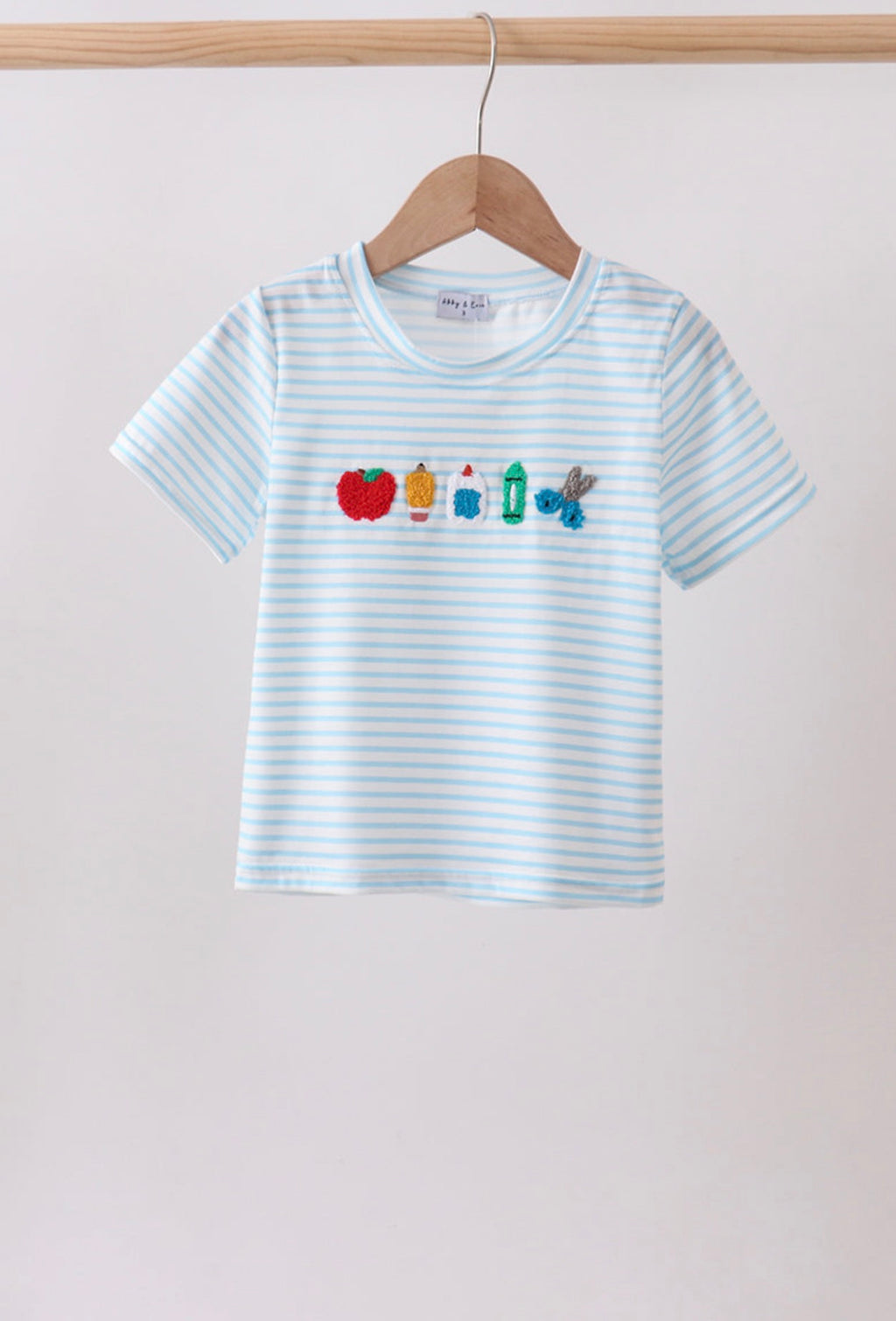 Striped t-shirt with colorful graphics on a hanger against a plain background